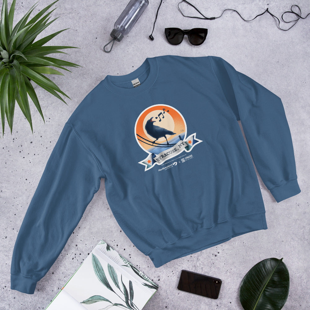 An indigo blue sweatshirt featuring an illustration of a crow on a telephone wire and a banner beneath it that says Syracuse, NY
