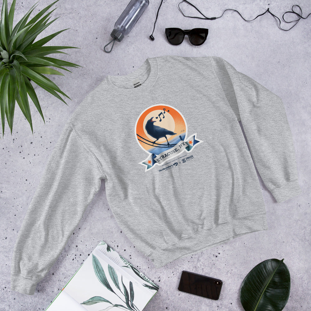 A sport grey sweatshirt featuring an illustration of a crow on a telephone wire and a banner beneath it that says Syracuse, NY