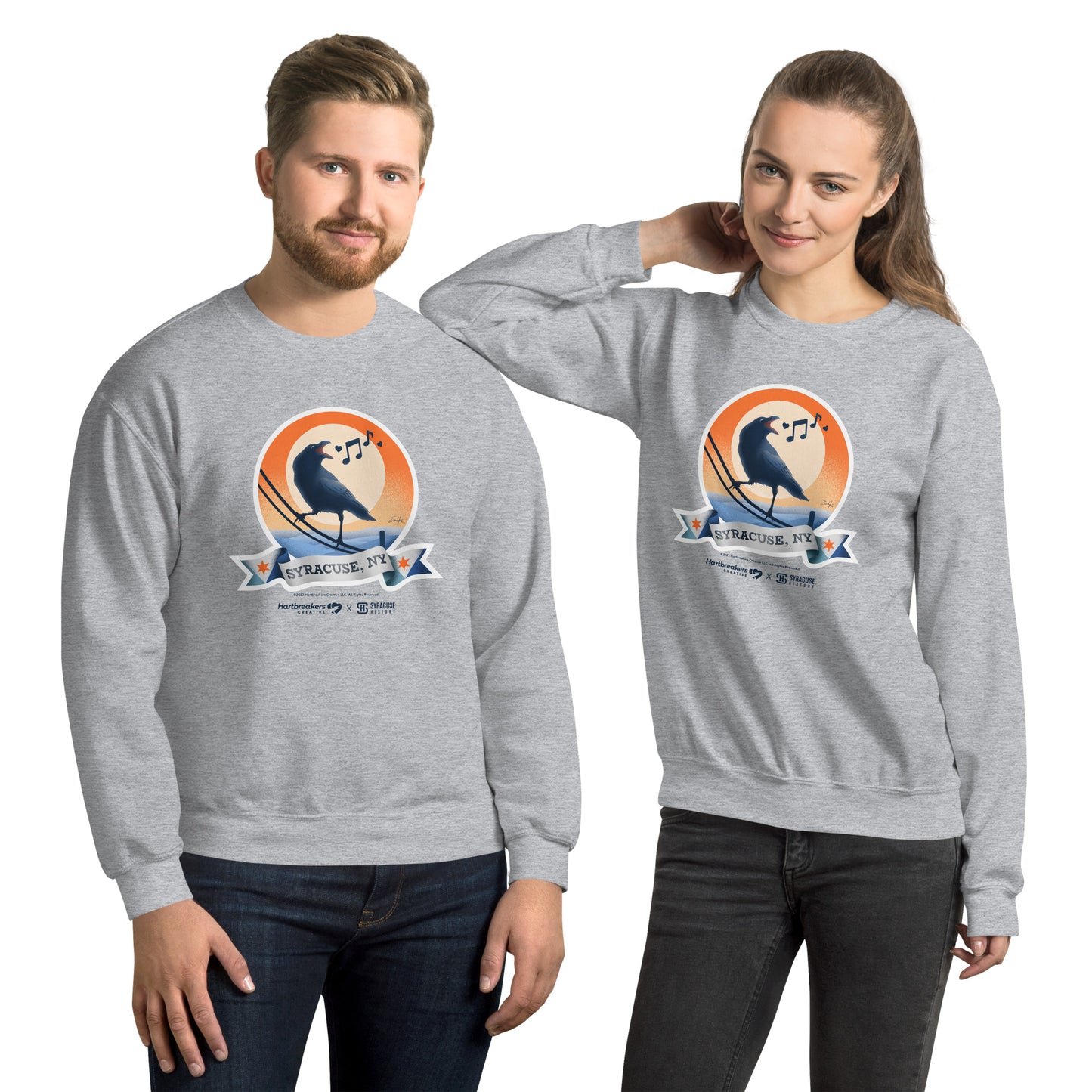 A man and woman wearing sport grey sweatshirts featuring an illustration of a crow on a telephone wire and a banner beneath it that says Syracuse, NY