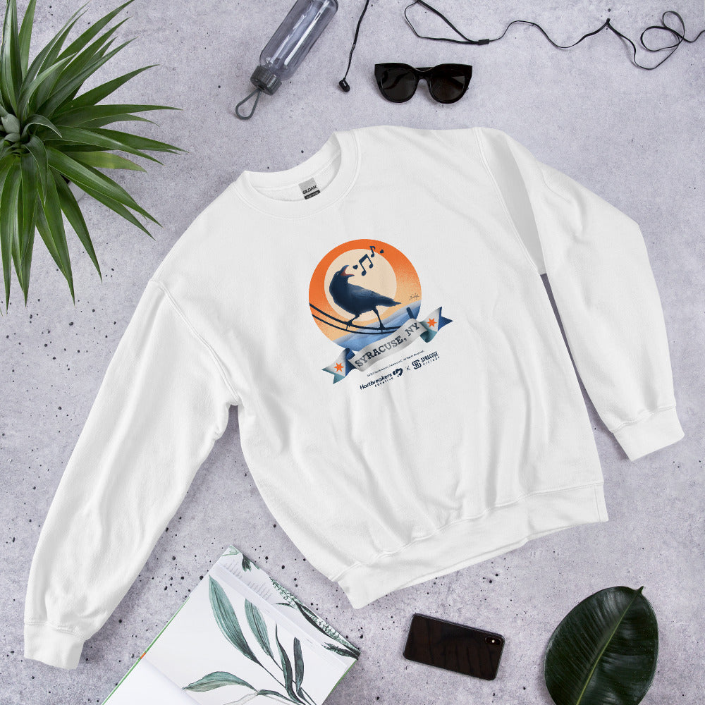 A white sweatshirt featuring an illustration of a crow on a telephone wire and a banner beneath it that says Syracuse, NY