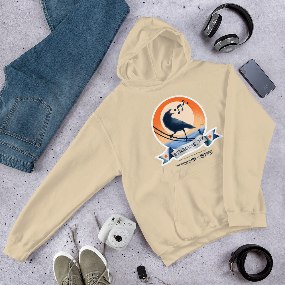 A sand-colored hoodie featuring an illustration of a crow on a telephone wire and a banner beneath it that says Syracuse, NY