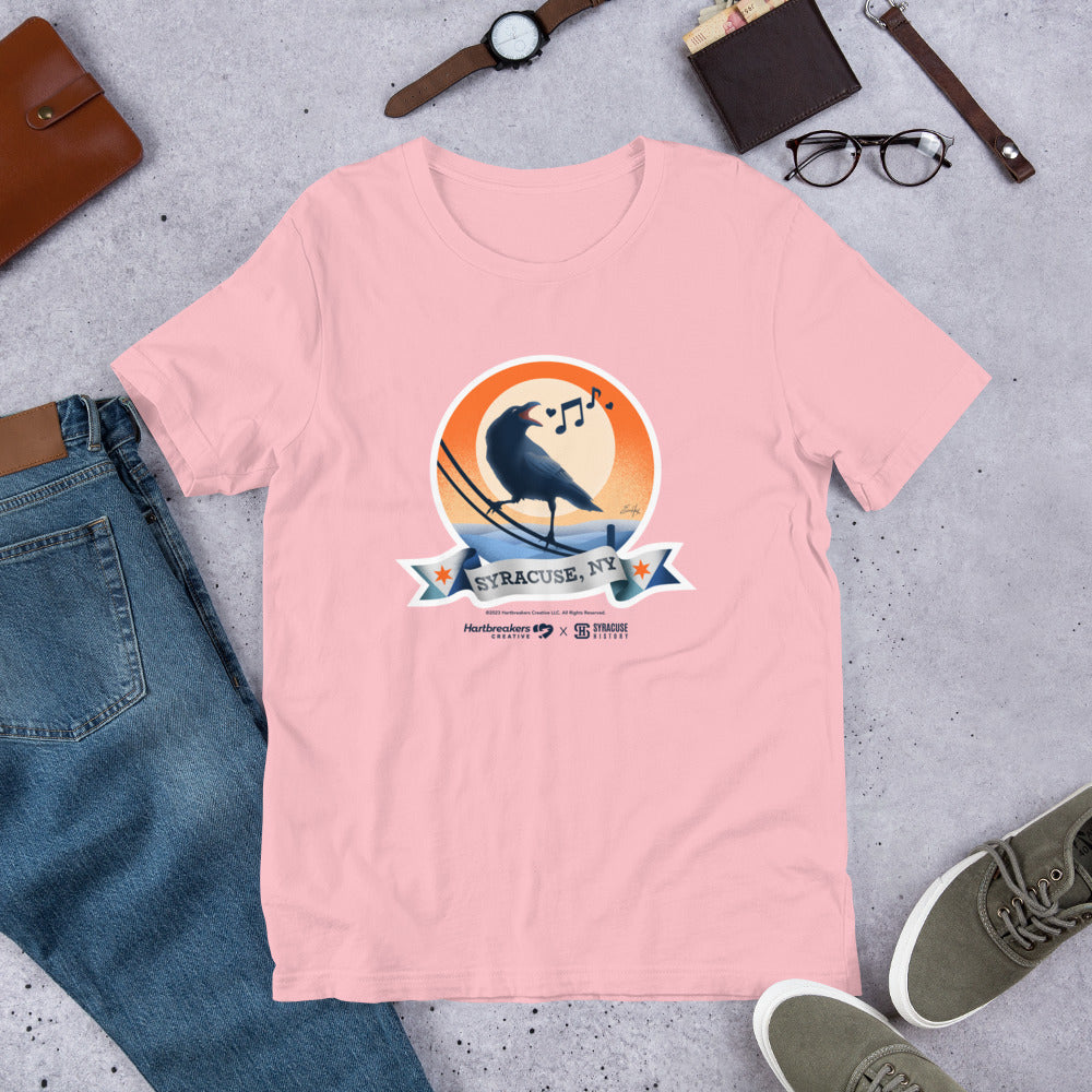 A pink T-shirt featuring an illustration of a crow on a telephone wire and a banner beneath it that says Syracuse, NY